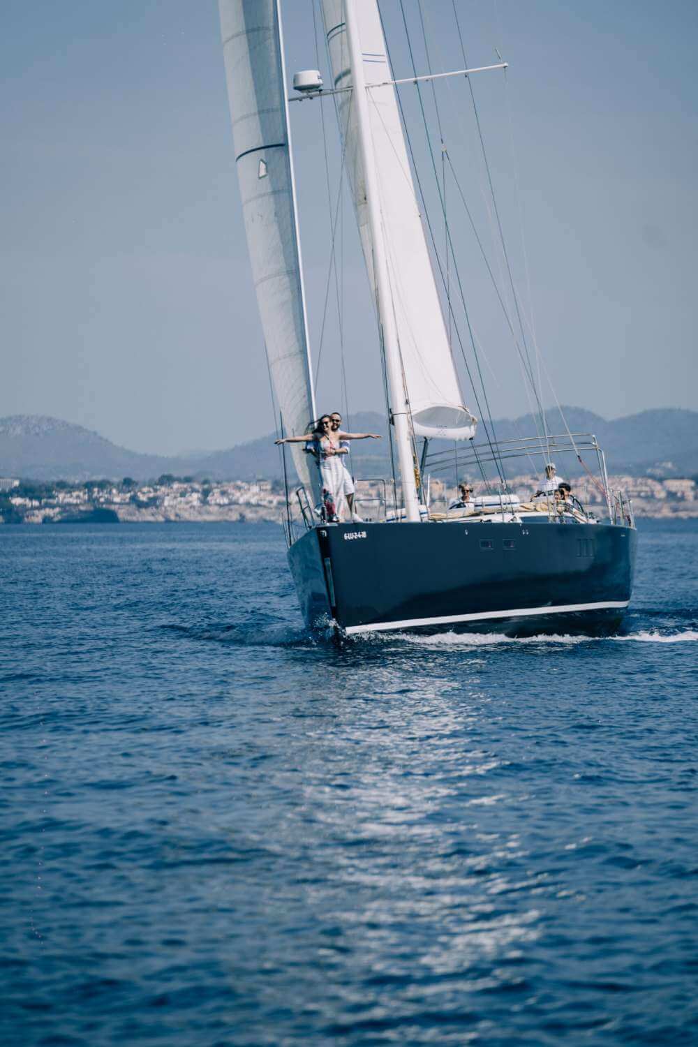 Pareja en la proa del velero navegando